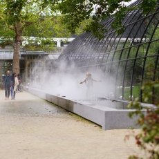 Little girl playing in the mist fountain