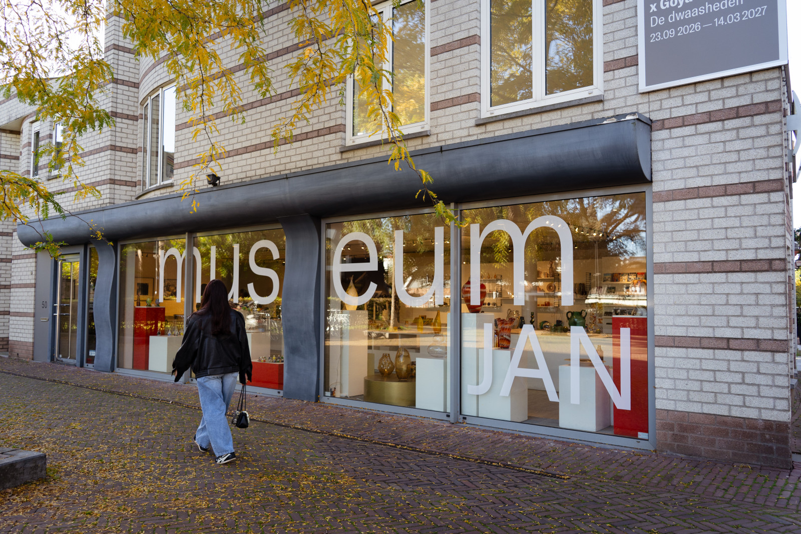 Woman walking past the entrance of Museum JAN in Amstelveen