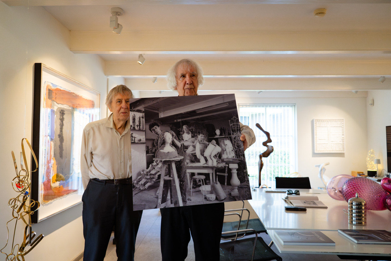 Jan Verschoor and his husband Rob Brünnmayer holding an old studio photograph at Museum JAN