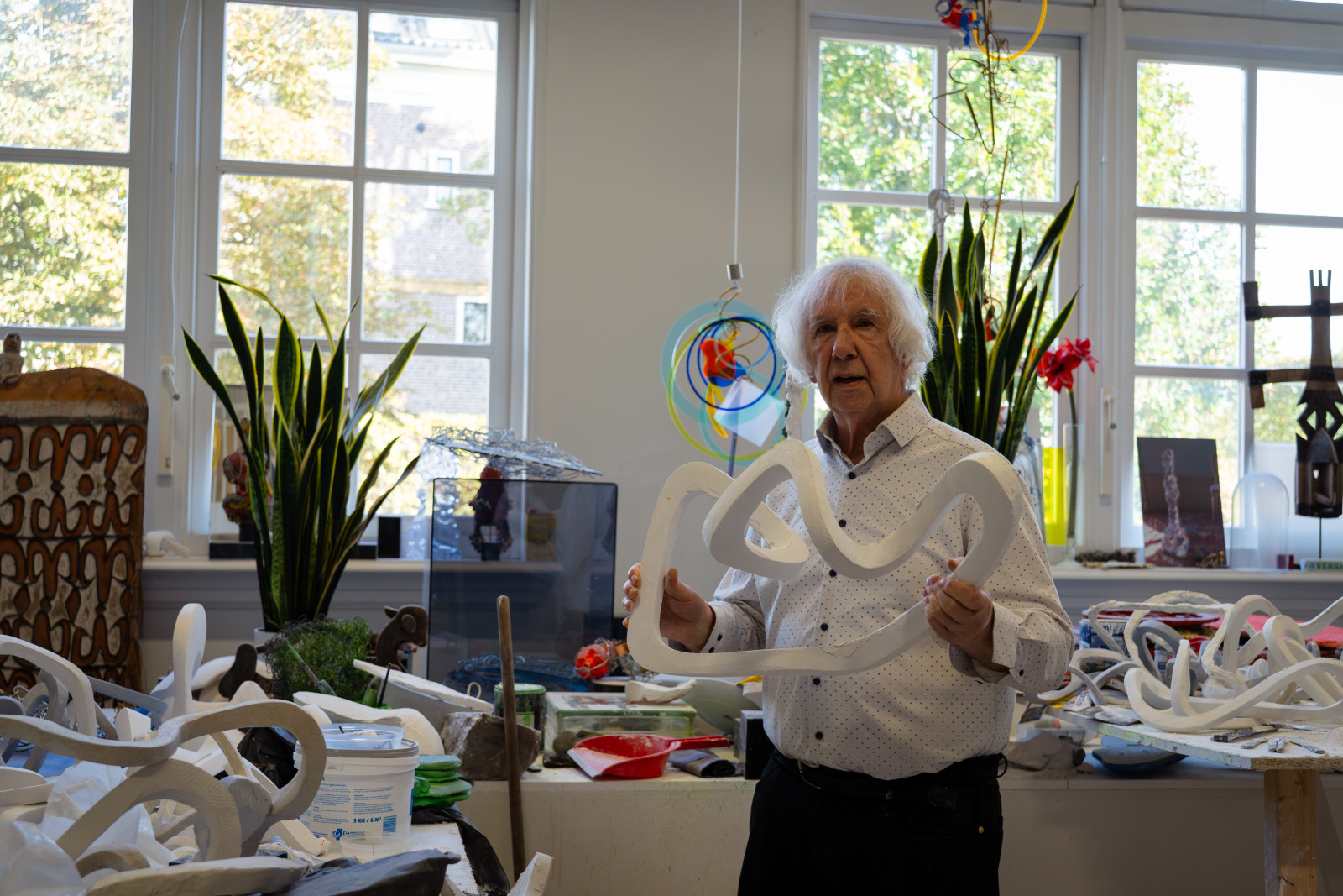Jan Verschoor holding a white sculpture in his studio next to Museum JAN