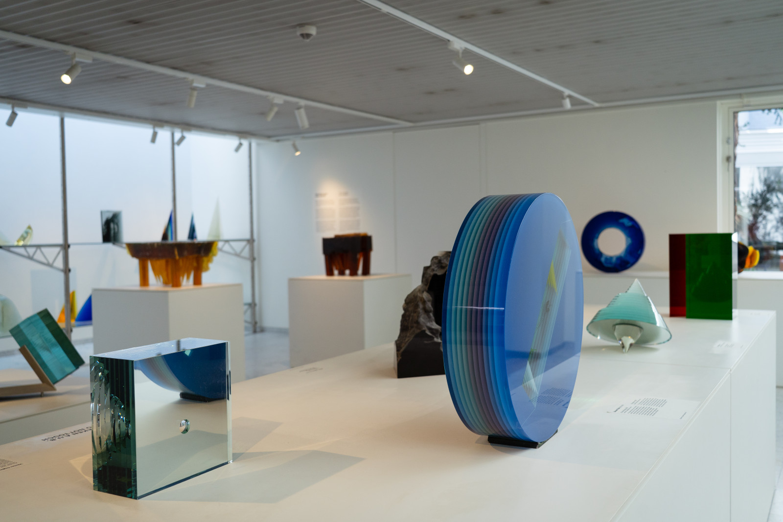 Modern glass art, including a layered blue disc, at Museum JAN