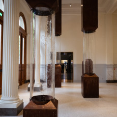 Entrance hall with white marble columns and glass column displays at ARTIS Aquarium