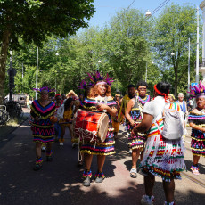 Drummers in purple feather headdresses at the Bigi Spikri parade, Amsterdam