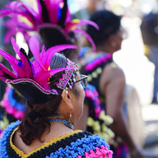 Woman in a pink feather headdress at the Bigi Spikri parade, Amsterdam