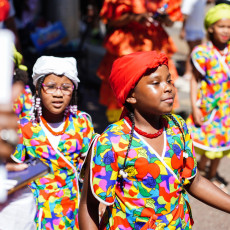 Children in bright koto dresses at the Bigi Spikri parade, Amsterdam