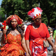 Two women in red koto dresses at the Bigi Spikri parade, Amsterdam