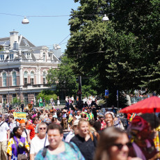 Bigi Spikri crowd on an Amsterdam street lined with historic buildings