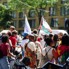Parade-goers with flags at the Bigi Spikri gathering, Amsterdam, Keti Koti