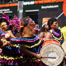 Dancers in feathered fringe costumes at the Bigi Spikri parade, Amsterdam