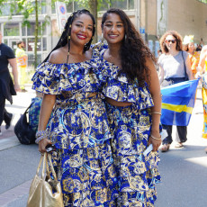 Two women in matching blue and gold koto dresses at Bigi Spikri, Amsterdam