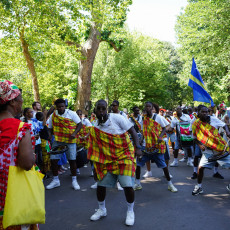 Men dancing with pangi cloths at the Bigi Spikri celebration in Oosterpark, Amsterdam