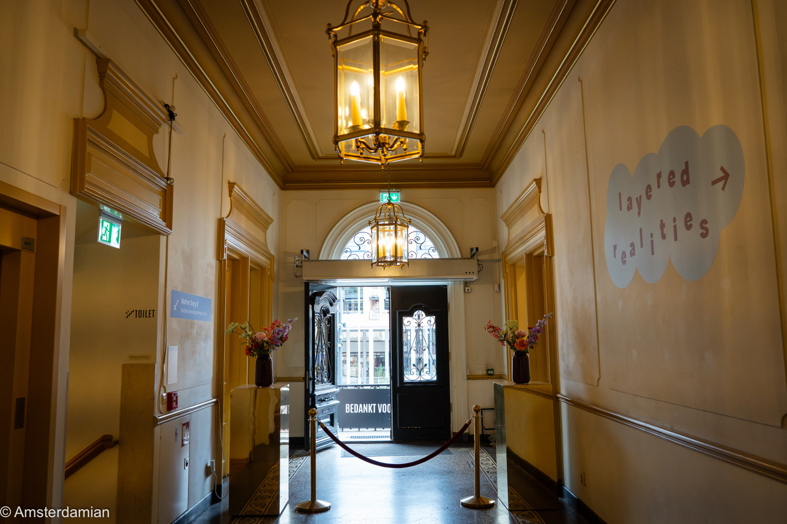 Entrance hall of Fotomuseum Hilversum with a brass lantern and exhibition sign