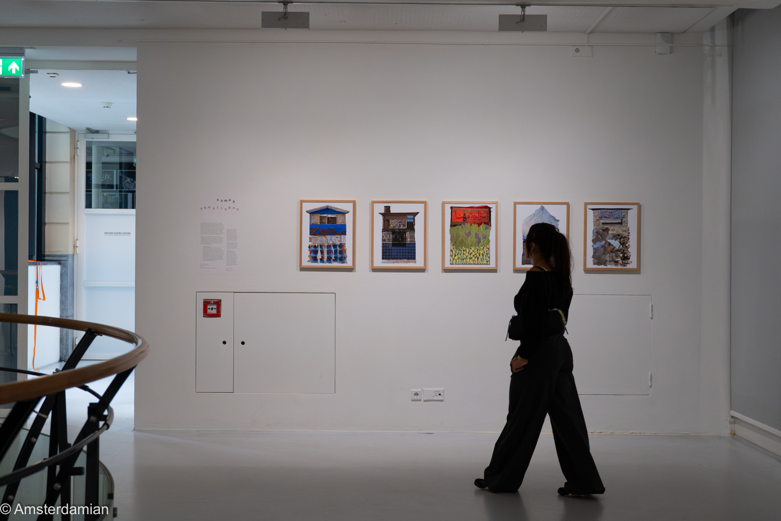 Woman walking past framed collage works at Fotomuseum Hilversum
