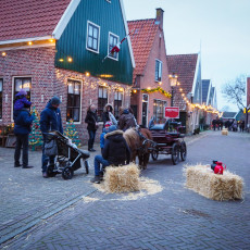 Pony and cart waiting between straw bales on a decorated street in De Rijp