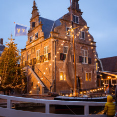 The 1630 town hall of De Rijp with a Christmas tree and a moored sailing barge