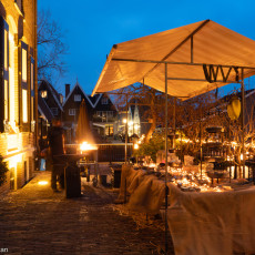 Candles laid out under an awning beside a brazier at the Midwinterfeest