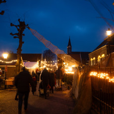 Crowds and candlelight along the Christmas market street in De Rijp at night