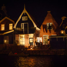 Gabled houses reflected in the water at the end of the Midwinterfeest evening