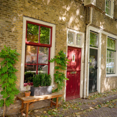 Old brick house with a red door in Oudewater