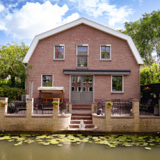 Brick house by a canal with water lilies