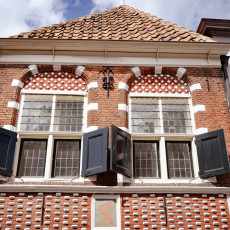 Old brick facade with black shutters