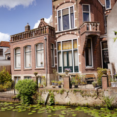 Brick villa by a canal with water lilies