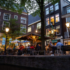 Canalside terrace at dusk, seen from the water in Amsterdam