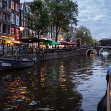 Narrow canal and a bridge at dusk, from an Amsterdam canal boat