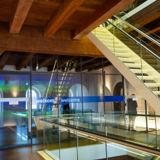 Glass staircase and welcome sign under the old beams of the maritime museum entrance