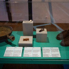 Finds from the sea bed, including a pan, a comb, a pipe and leather shoes, in a case