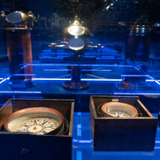 Old ships' compasses in wooden boxes in the navigation section of the museum
