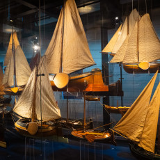 Models of sailing boats with rigged canvas sails behind glass in the model gallery