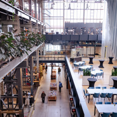 Cafe tables and greenery on the LocHal's upper level