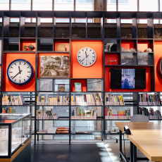 Old railway clocks above the bookshelves in the LocHal