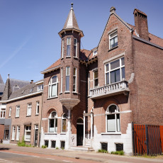 A brick villa with a corner turret on a Tilburg street