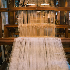 Warp threads on a wooden handloom at the TextielMuseum