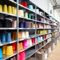 Shelves of coloured yarn cones in the TextielLab
