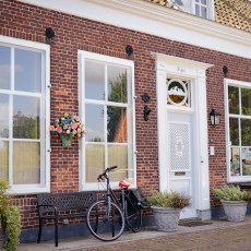 Brick house front with a bicycle and flower basket, Veere