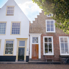 White gabled house beside a brick stepped-gable house in Veere