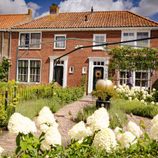 Brick house with a flowering front garden in Veere