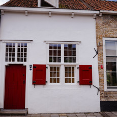 White house with a red door and shutters on the Markt in Veere