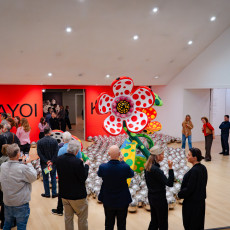 Visitors around Kusama's dotted flower sculpture and silver mirror balls