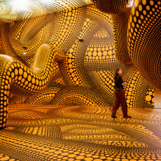 A visitor walking through Kusama's dotted tentacle room at the Stedelijk