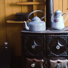 Enamel kettle and coffee pot on a cast-iron stove in a period kitchen at the Zuiderzeemuseum
