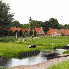 Red-roofed houses and a church tower across the grass in the Zuiderzee Village, Enkhuizen