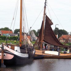 Historic Dutch sailing barges moored in the harbour of the Zuiderzeemuseum open-air village