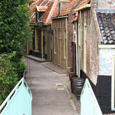 Cobbled lane and painted footbridge between historic houses in the Zuiderzee Village