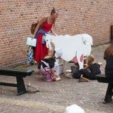 Children learning to milk a wooden cow at the Zuiderzeemuseum, Enkhuizen
