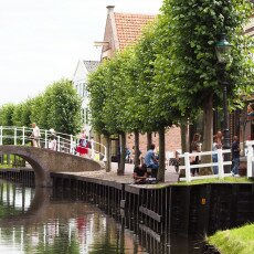 Canal, humpback bridge and shopfronts in the Zuiderzeemuseum open-air village, Enkhuizen