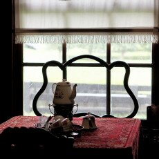 Coffee pot on a table by the window in a dark period living room at the Zuiderzeemuseum